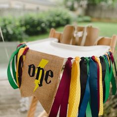 there is a one sign hanging on the clothes line with other ribbons around it and an umbrella in the background