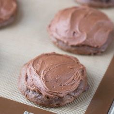 chocolate cookies with frosting sitting on a baking sheet, ready to be baked in the oven