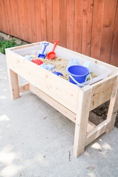 a sandbox with shovels and toys in it