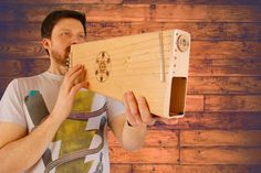 a man is holding a wooden instrument in front of his face