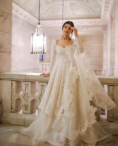 a woman in a wedding dress standing on a balcony