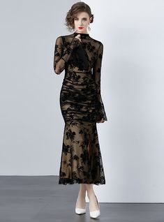 Mystique becomes tangible in this delicately crafted black lace dress that exudes both elegance and sensuality. A sheer overlay with intricate floral patterning cascades over a sleek, form-fitting underlay, creating a dance between concealment and revelation. The full-length sleeves bloom into fluted cuffs, adding a touch of dramatic flair, while the high neckline balances the ensemble with a touch of traditional grace. Perfect for gala events or sophisticated soirées, this dress demands attenti Party Lace Dress With Scalloped Lace And Stretch, Fitted Scalloped Lace Evening Dress, Fitted Lace Evening Dress With Scalloped Lace, Fitted Lace Evening Dress With Scalloped Detail, Scalloped Lace Stretch Dress For Party, Stretch Scalloped Lace Dress For Party, Sheer Fitted Lace Dress For Gala, Stretch Lace Evening Dress, Fitted Lace Dress With Lace Trim For Gala