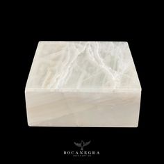 a white marble block sitting on top of a black background with the words bocanegra above it