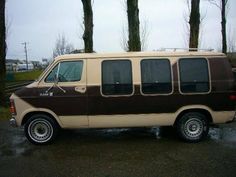 an old van is parked on the side of the road in front of some trees