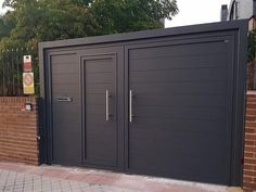 a large metal gate with two doors on each side and brick wall around it, along with a brick walkway