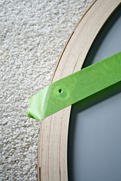 a close up of a clock on the floor with green tape around it's face