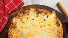 a cheesy pizza sitting on top of a wooden cutting board