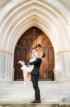 a bride and groom are posing in front of an old church door for their wedding photo