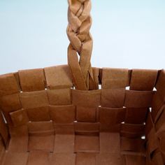 a basket made out of brown paper with some sort of knot on the top and bottom