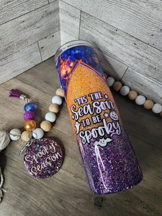 this the season to be sparkle tumbler with keychain and beads on wooden floor