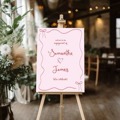 an easel with a sign on it in front of a room filled with tables and chairs