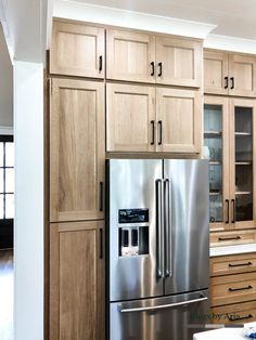 a stainless steel refrigerator in a kitchen with wooden cabinets