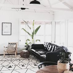 a living room with white walls and black furniture