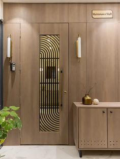 a room with wooden paneling and gold accents on the door, two vases in front of it