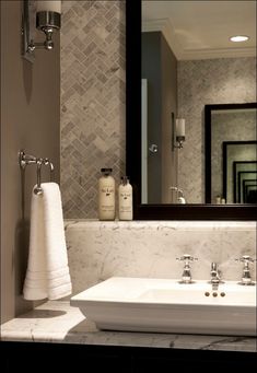 a white sink sitting under a mirror in a bathroom