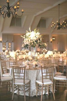 the tables are set with white flowers and candles