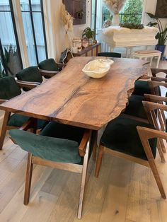 a wooden table with green chairs around it