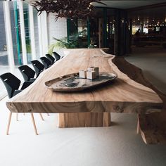 a wooden table with black chairs and a plate on it