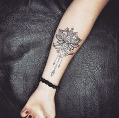 a woman's arm with a tattoo that has a flower on it and an arrow in the middle