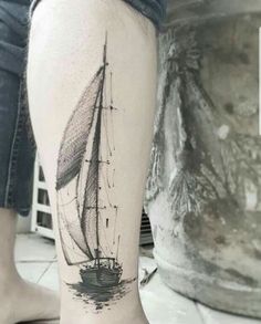 a woman's leg with a small tattoo of a sailboat on the water