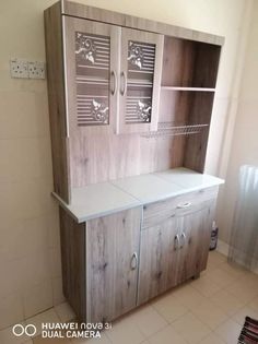 a cabinet with doors and drawers in a room that has tile flooring on the walls