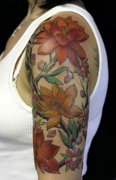 a woman's arm with flowers on it, and an orange flower in the middle