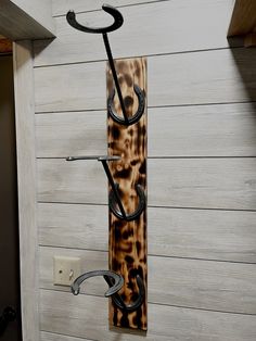 a coat rack made out of wood and metal with an umbrella hanging from it's side