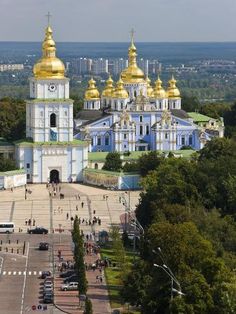 an aerial view of a large building with gold domes on it's sides and trees in the foreground