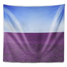 a purple field with blue sky and clouds in the background tapestry wall hanging art print