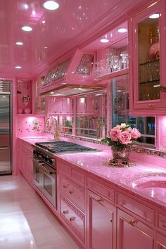 a pink kitchen with lots of counter space and lights on the ceiling, along with white tile flooring