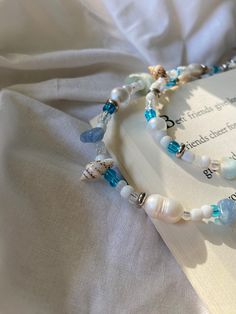 OCEAN is a very beautiful and unique waist chain! The combination of glass beads, pearls, seashells, and aquamarine creates a lovely mix of textures and colors. The glass beads add a shimmering effect to the chain, while the pearls and seashells create a more organic, beachy feel. Aquamarine helps us gain truth and wisdom. It can also help calm the soul and help eliminate any stress in your life.  🌊 🌊 🌊  OCEAN comes in 3 different sizes, XS, S, and M The XS measures 25 inches at its smallest Blue Beaded Necklace With Pearl Charm For Beach, Blue Pearl Beaded Necklaces For Beach, Colorful Ocean-inspired Beaded Necklaces, Ocean-inspired Colorful Round Beaded Necklaces, Blue Pearl Beaded Bracelets For Beach, Pearl Beaded Necklace With Gemstone Beads For Beach, Summer Beach Pearl Beads, Beaded Waist Chain, Belly Chain