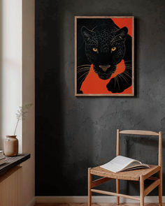 a black cat on an orange background hangs above a wooden chair in a dark room