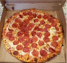 a pepperoni pizza in a box on a table