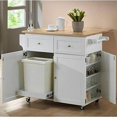 a white kitchen island cart with two trash cans on the top and one open drawer