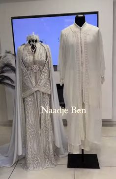 two white gowns on display in front of a tv