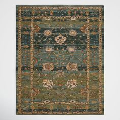 a green rug with an intricate design on the front and back side, in various colors