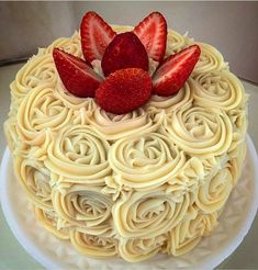 a cake with white frosting and strawberries on top