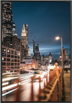 the city skyline is lit up at night, with cars moving on the road and buildings in the background