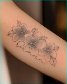 a woman's arm with flowers on it and leaves around the wrist tattoo design