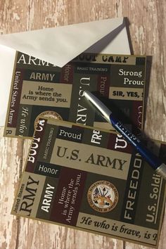 an envelope with us army stickers and a pen on it next to the envelope