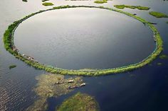 an aerial view of a large circular island in the middle of a body of water