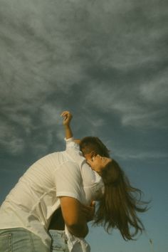 a man and woman flying a kite in the sky