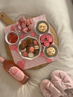 a tray filled with cupcakes and candy on top of a bed