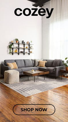 a living room with wooden floors and furniture on display in front of a large window