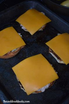 four square sandwiches with cheese on them in a pan