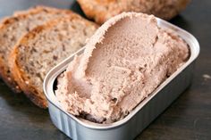 an open tin of ice cream sitting on top of a table next to sliced bread