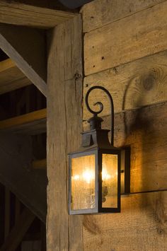 a light that is on the side of a wooden wall next to a door and window