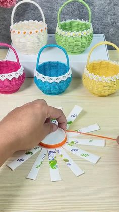 the person is making baskets with paper and scissors