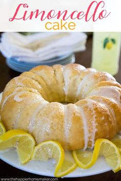 a lemon cake on a white plate with sliced lemons around it and the words lemoncelle cake