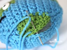 crocheted ball of yarn with needles and buttons